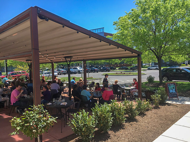 A Restaurant Patio With A Gennius Rectractable Awning